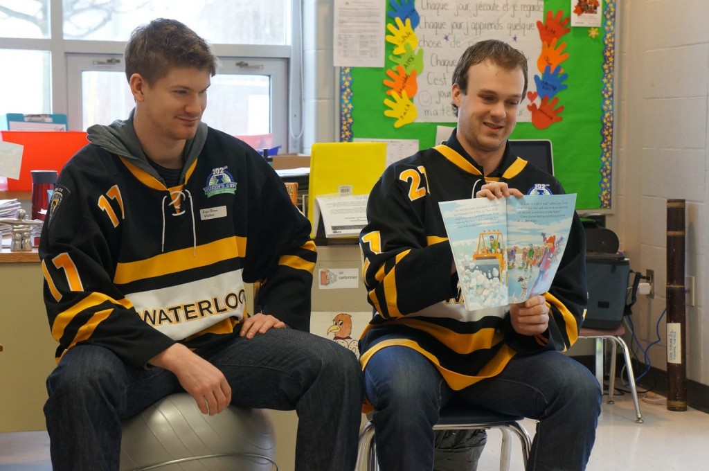 Varsity hockey players reading to elementary school students